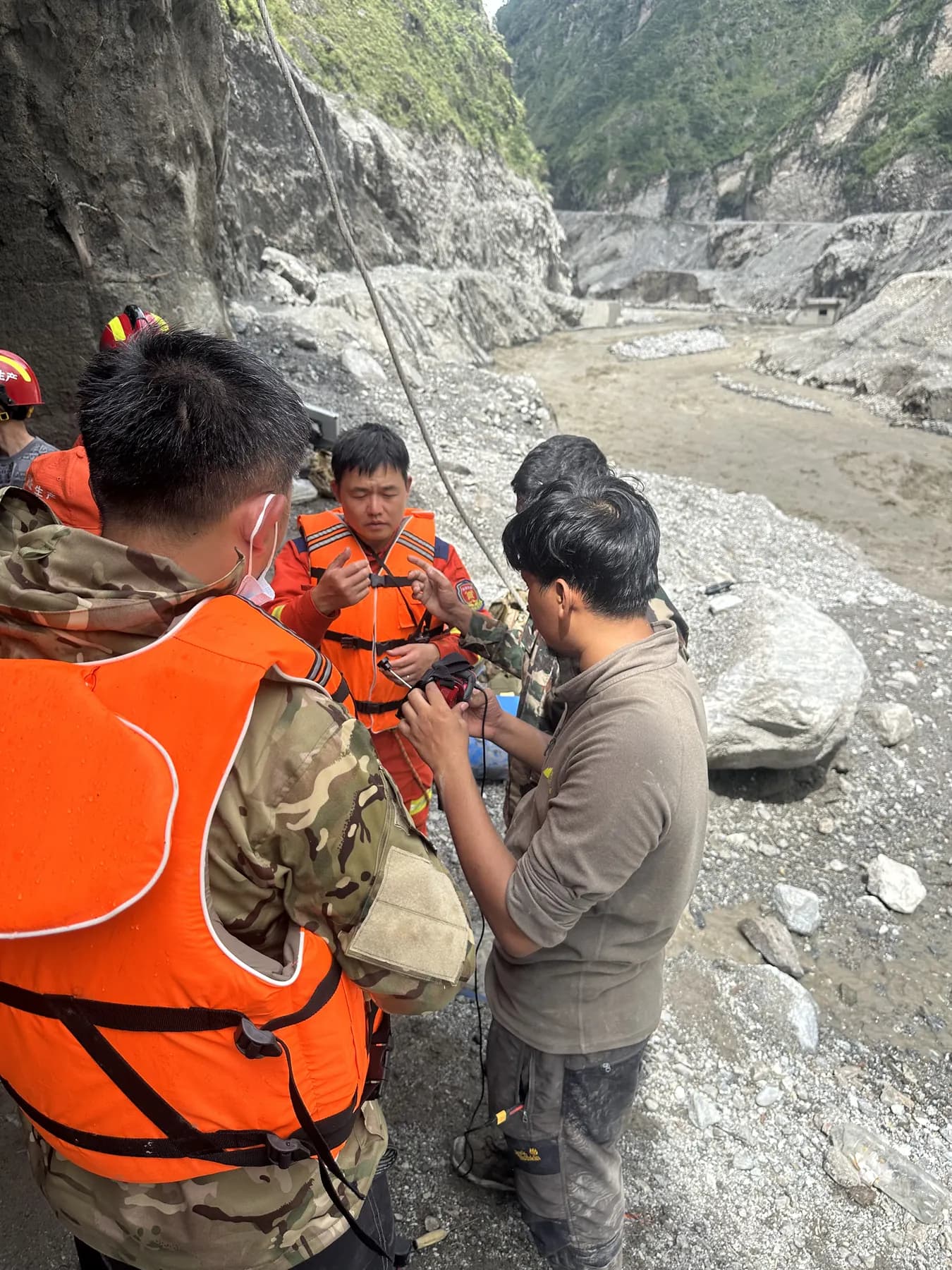Rescue workers in life jackets with Adarsha in the flood-hit Trishuli gorge, August 2026