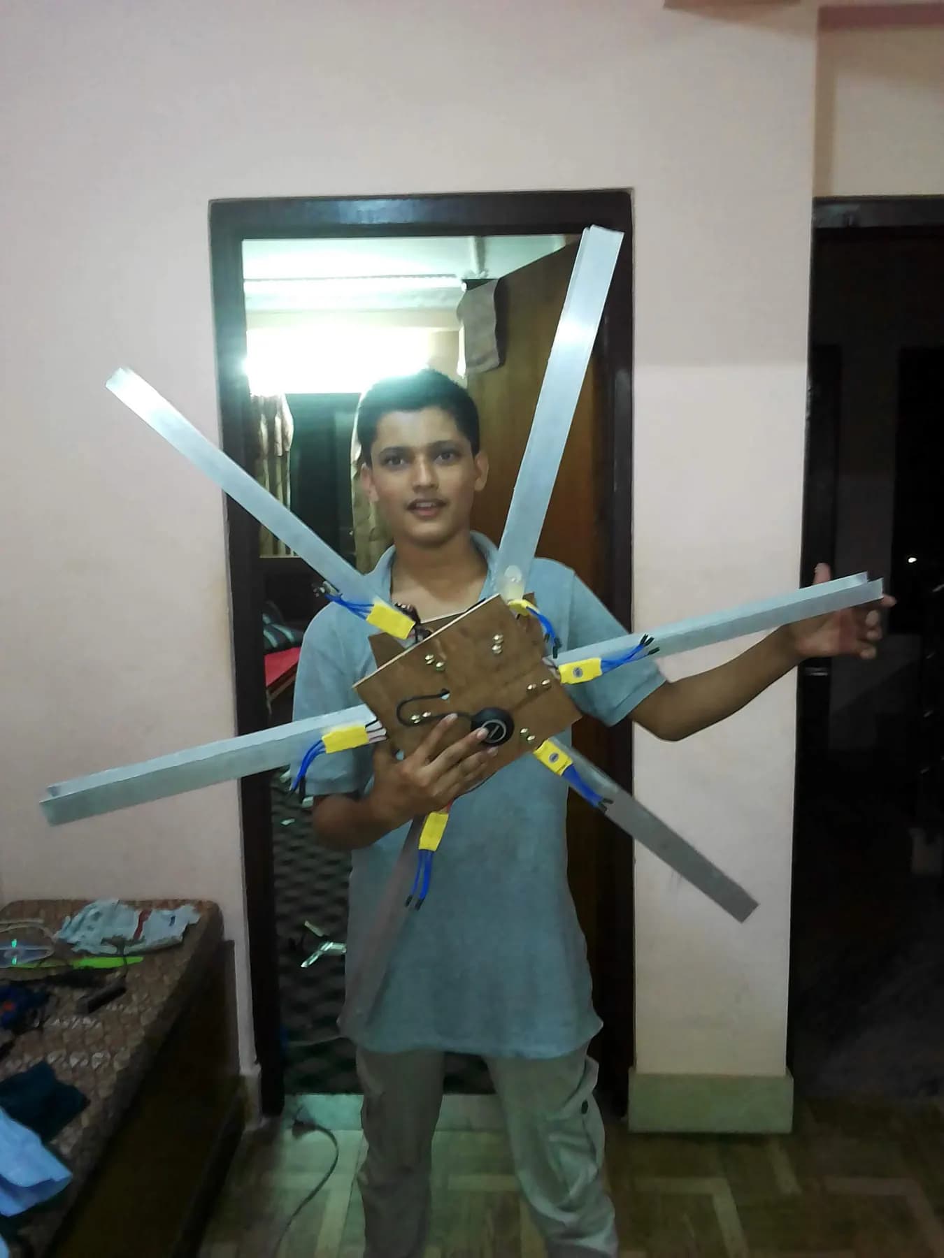 Adarsha holding a large X-frame airframe with aluminium arms, 2018