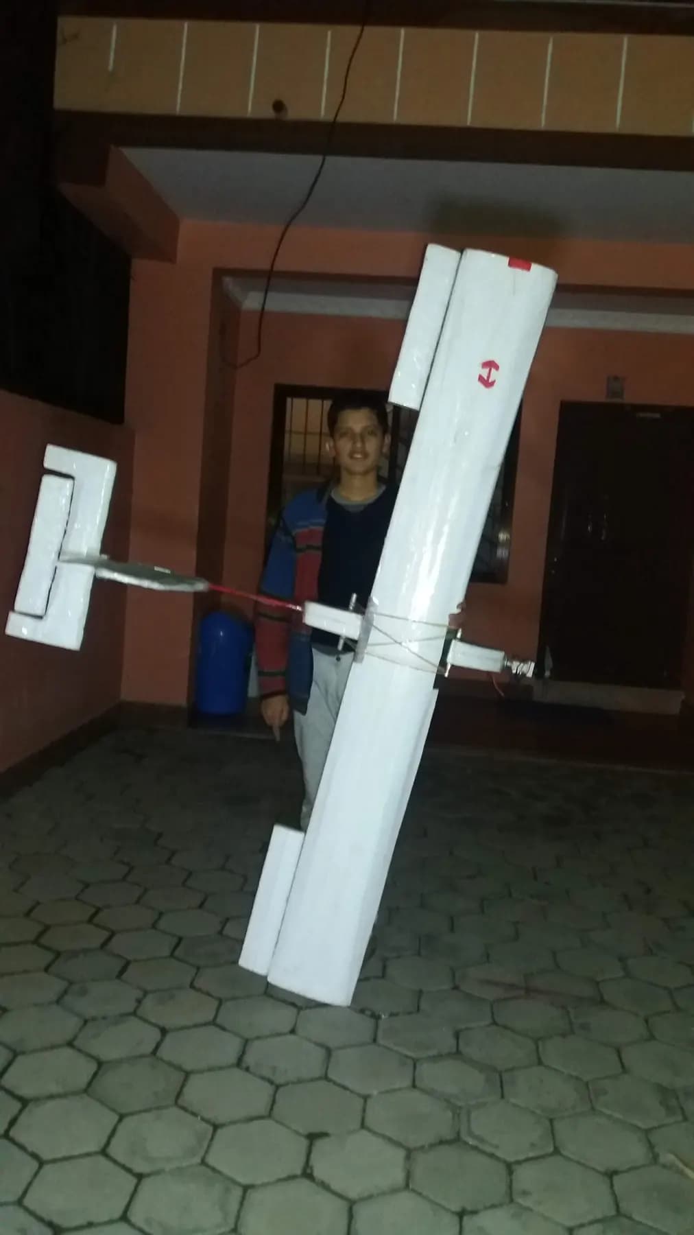 Adarsha with a foam fixed-wing aircraft at night, 2019