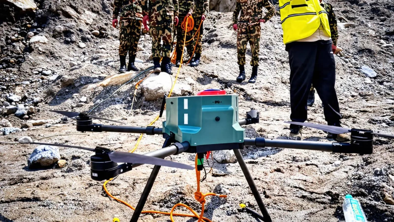 A line-stringing drone on flood debris, its line held by soldiers, August 2026